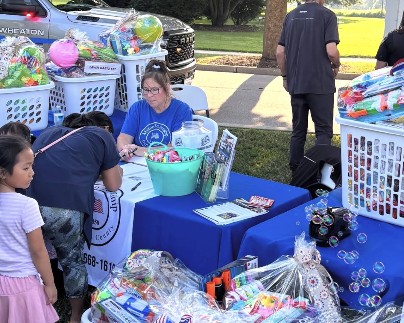 National Night Out Raffle to win gift basket Milton Staff at table with residents signing up
